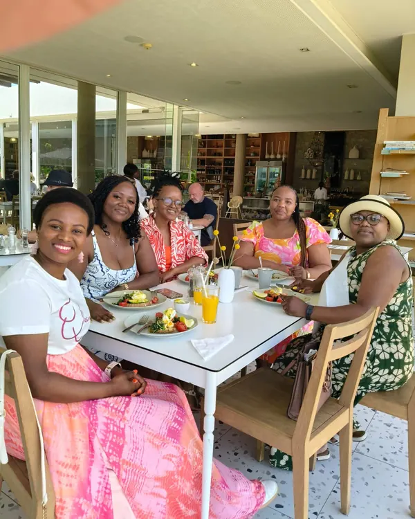 Women smiling together around a brunch table